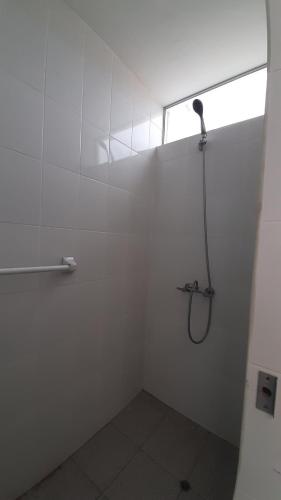 a white bathroom with a shower with a window at CASA DE PLAYA Durante todo el año in Punta Negra