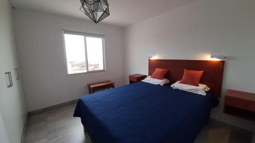 Un dormitorio con una cama azul y una ventana en CASA DE PLAYA Todo el año, en Punta Negra
