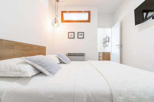 a white bedroom with a large white bed at Villa Radić in Makarska