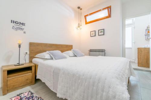 a white bedroom with a large bed and a window at Villa Radić in Makarska
