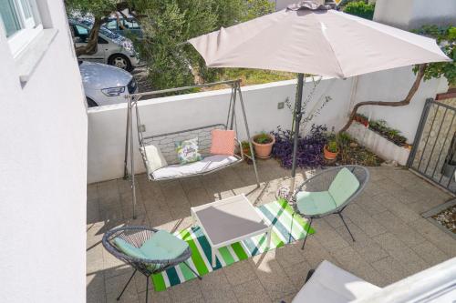 a patio with two chairs and an umbrella at Villa Radić in Makarska
