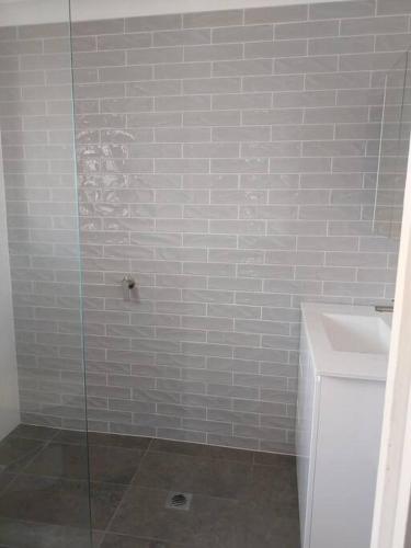La salle de bains est pourvue d'une douche et d'un lavabo. dans l'établissement Chic 2 Bed, 2 Bath Retreat in Burleigh Waters, à Gold Coast