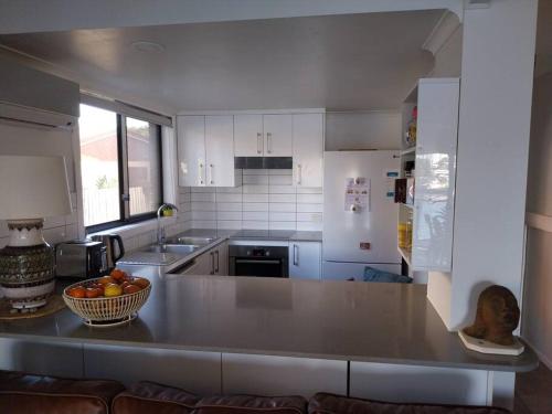 - une cuisine avec un bol de fruits sur un comptoir dans l'établissement Chic 2 Bed, 2 Bath Retreat in Burleigh Waters, à Gold Coast