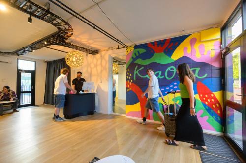 a group of people standing in a room with a colorful wall at Urban Lounge Sleepery in Rotorua