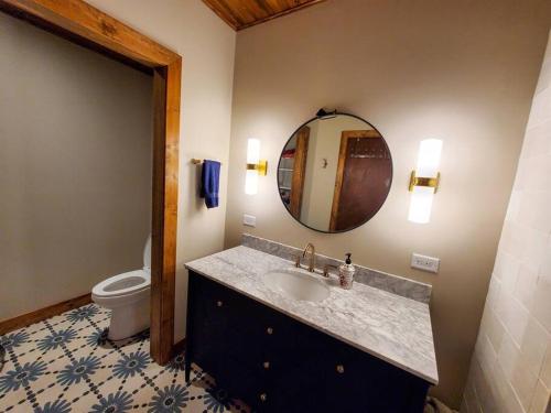 a bathroom with a sink and a toilet and a mirror at Juneau Cabin near Eaglecrest & Trails in Juneau