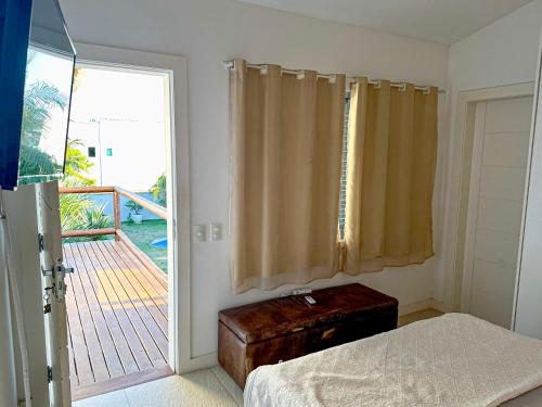 - une chambre avec un lit et une porte donnant sur un balcon dans l'établissement Pousada Mansão Triplex Jolly, à Búzios