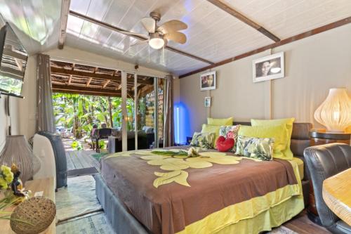 - une chambre avec un lit et un ventilateur de plafond dans l'établissement Fare Oaoa Haapiti, à Moorea