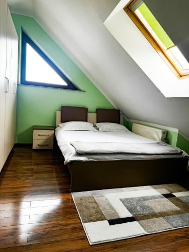 um quarto com uma cama e uma parede verde em Adonis Oasis Rădăuți em Rădăuţi