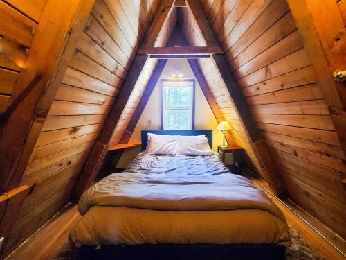 een slaapkamer met een bed op een houten zolder bij Cabin & A-Frame w/ Firepit near Fishing & Trails in Juneau