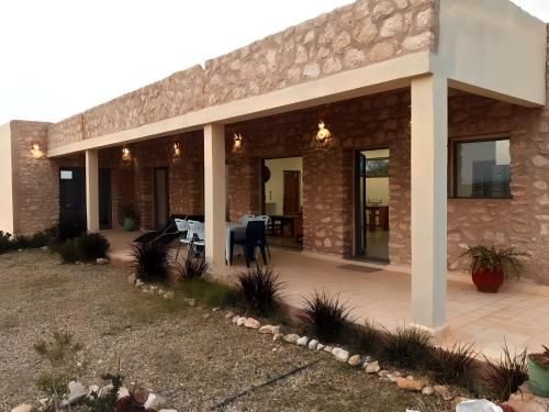 um edifício de tijolos com um pátio com uma mesa em Villa Boujmaa in Sidi Kaouki em Sidi Kaouki