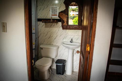 a small bathroom with a toilet and a sink at El Pozzo Hotel Campestre in Villa de Leyva