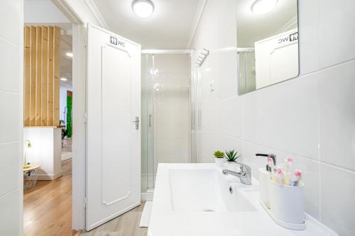 a white bathroom with a sink and a mirror at Sintra Nest - Near the train to Lisbon and Sintra (3 min) in Sintra