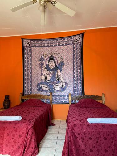 グラナダにあるCasa608のベッド2台が備わる客室で、壁には絵画が飾られています。
