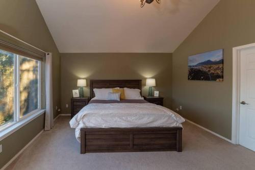 Un dormitorio con una cama grande y una ventana en Juneau Oceanfront Home Overlooking Auke Bay en Mendenhaven