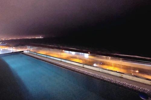 una piscina de agua por la noche junto a una autopista en Hermoso dpto con Vista al Mar, Piscina y Sauna, en Lima