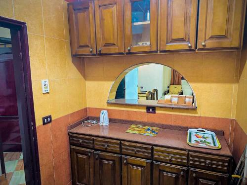 eine Küche mit einer Theke mit einem Waschbecken und einem Spiegel in der Unterkunft Ramses Downtown Apartment in Luxor