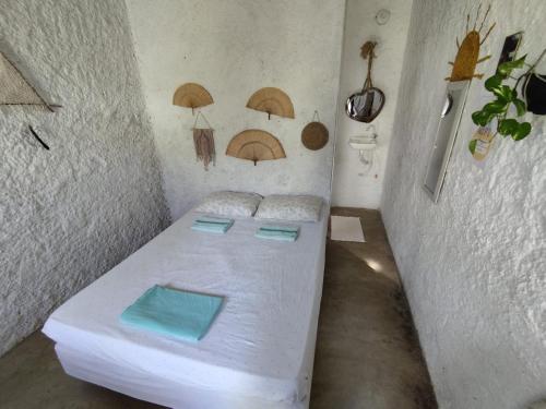 a small room with a bed with umbrellas on the wall at Hostel Flor da Vida in Canoa Quebrada