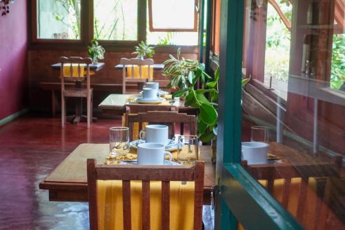 a restaurant with wooden tables and chairs in a room at Pousada Canto Verde in Tiradentes
