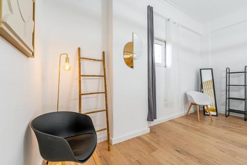 einen schwarzen Stuhl in einem Raum mit einer Leiter in der Unterkunft Sintra Nest & Loft by Lisbon with Sintra in Sintra