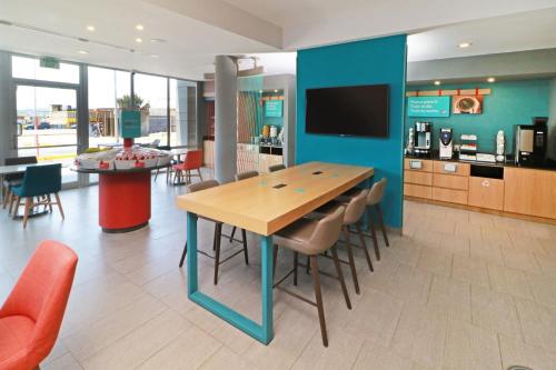 a dining room with a table and chairs and a tv at avid hotels - Tijuana - Otay by IHG in Tijuana