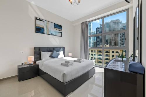a bedroom with a large bed and a large window at Luxe Living: Dec Marina Haven_1br in Dubai Marina in Dubai