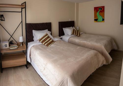 two beds sitting next to each other in a bedroom at La Puerta Del Sol in Arequipa