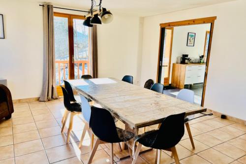 a dining room with a wooden table and chairs at Pretty triplex with garden and view in Puy-Saint-Pierre