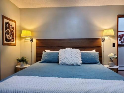 a bedroom with a blue bed with two lamps at Ocean & Mountain View Duplex, both sides in Juneau