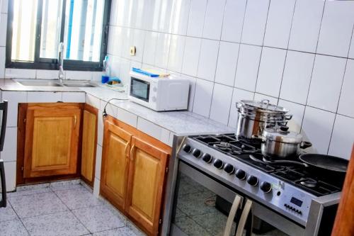uma cozinha com um fogão e um micro-ondas em NANCY em Limbe
