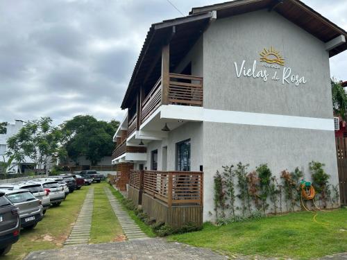 a building with a sign on the side of it at Pousada Vielas do Rosa - centrinho da praia do rosa in Praia do Rosa