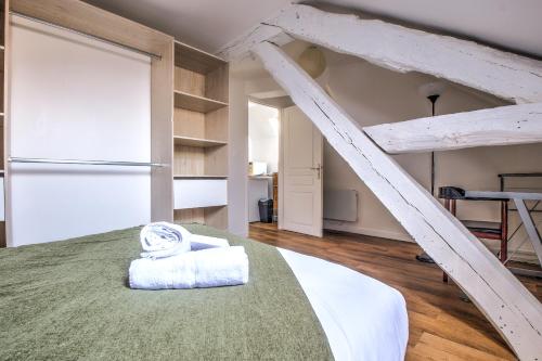 1 dormitorio con 1 cama grande y escalera en Le St Martin, en Périgueux
