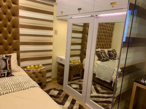 a small room with a bed and a mirror at JAMAHSA CONDO STAYCATION TREES RESIDENCES NEAR SM FAIRVIEW in Manila