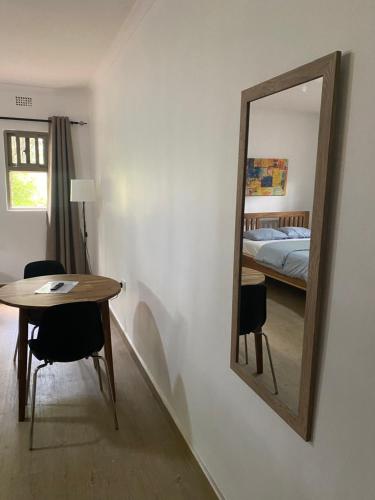 a mirror in a room with a table and a bed at The ranch apartments, en-suite rooms in Lusaka