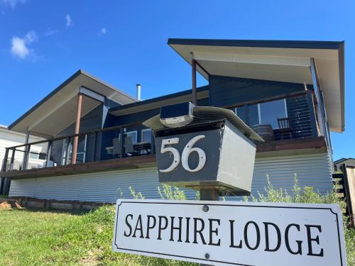 a house with a sign in front of it at Sapphire Lodge in Bermagui