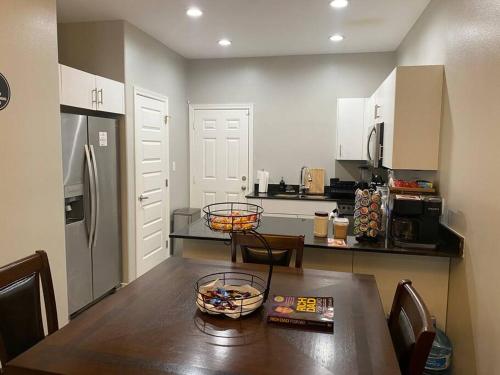 a kitchen with a wooden table with chairs and a refrigerator at Spacious Getaway near UTRGV in Edinburg