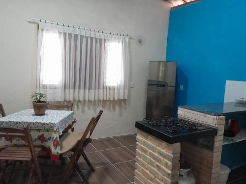 a kitchen with a stove and a table and a table and a tableablish at Chalé Primavera in Guaramiranga
