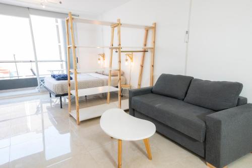 salon z kanapą i łóżkiem w obiekcie Alucinante studio! Centrico Moderno con balcon, apto 3 personas 71 w BuenosAires