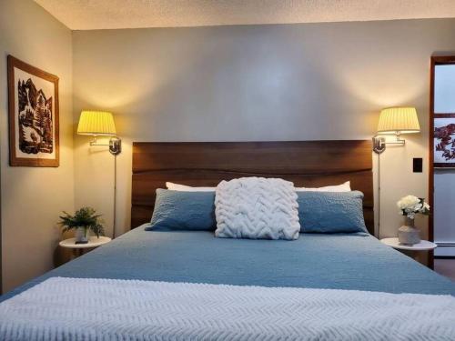 a bedroom with a blue bed with two lamps at Updated Duplex with Mountain & Filtered Water View in Juneau