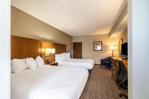 a hotel room with two beds and a flat screen tv at Best Western Bridgeview Hotel in Superior