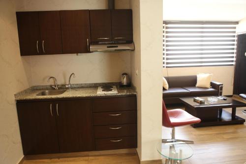 a kitchen with a sink and a couch in a room at Dreams Suites in Beirut