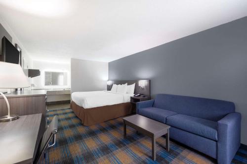 a hotel room with a bed and a blue couch at Quality Inn Memphis Downtown in Memphis