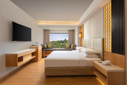 a hotel room with a bed and a television at Courtyard by Marriott Tiruchirappalli in Tiruchchirāppalli