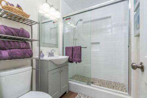 a bathroom with a sink and a shower with purple towels at Acogedora Casa Cerca de Todo in Los Angeles