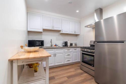 a kitchen with white cabinets and a stainless steel refrigerator at Acogedora Casa Cerca de Todo in Los Angeles