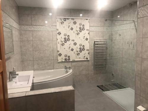 a bathroom with a bath tub and a sink at Heulwen Guest House in Dolgellau
