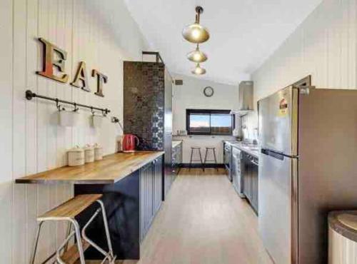 a kitchen with a stainless steel refrigerator and a counter at Charming 3 bedroom wine country cottage in Rutherglen