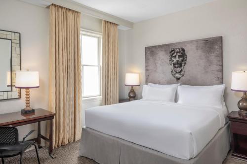 a bedroom with a large white bed and a desk at Crowne Plaza New Orleans French Qtr - Astor by IHG in New Orleans