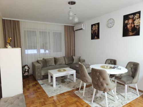 salon z kanapą i stołem w obiekcie Apartman Tajna w mieście Sremčica