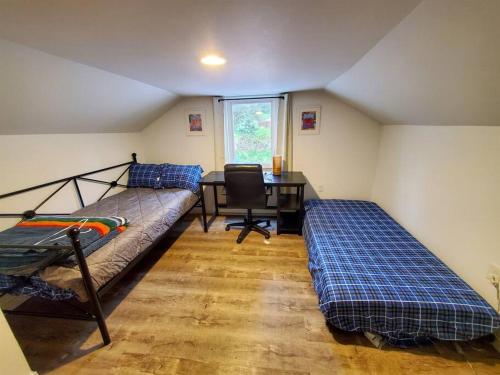 a room with two beds and a desk in it at Ocean & Mountain View Home, near Downtown Juneau in Juneau