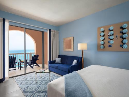 um quarto com uma cama, um sofá e uma varanda em The Reefs Resort and Club em Southampton